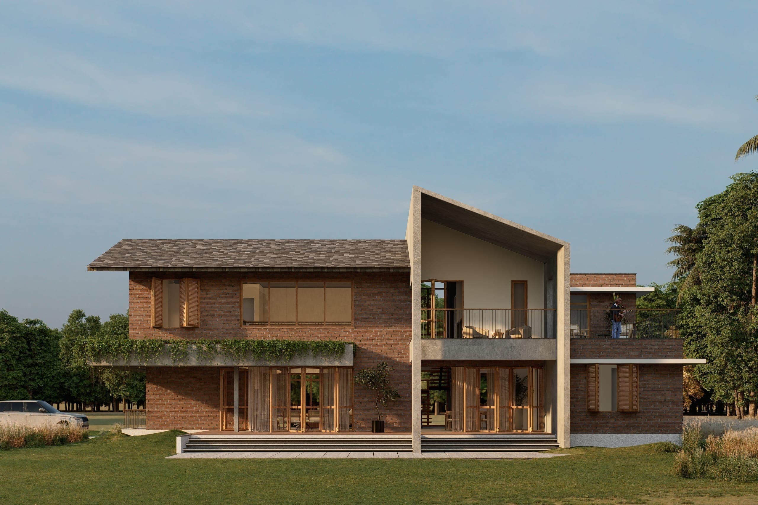 The rear opens into a deep veranda that extends the living spaces outward. This edge becomes a transitional zone where interior activity gradually dissolves into the landscape.