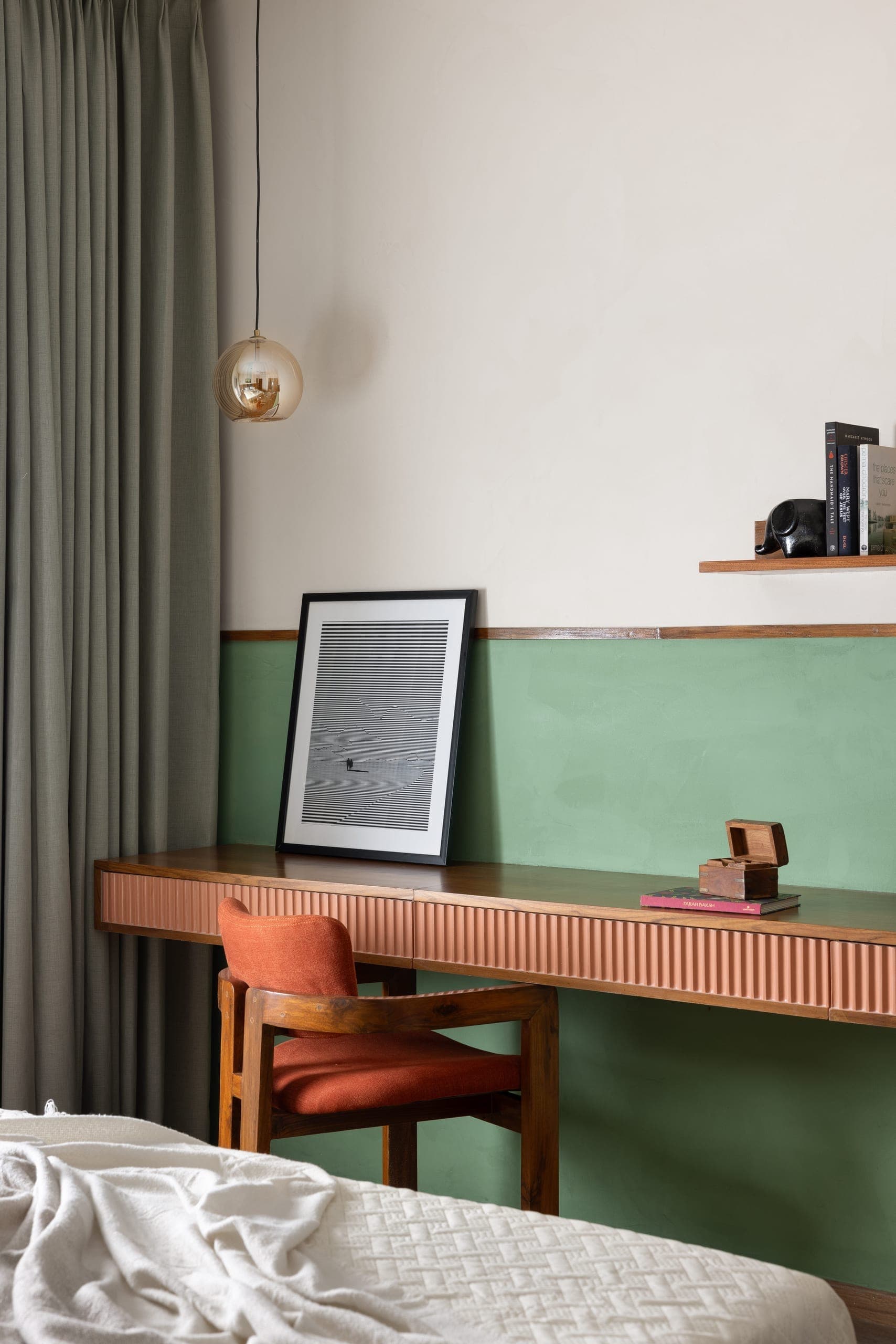 A continuous teak fluted panel organises the bed wall, integrating the headboard, with a compact brass sconce for light.