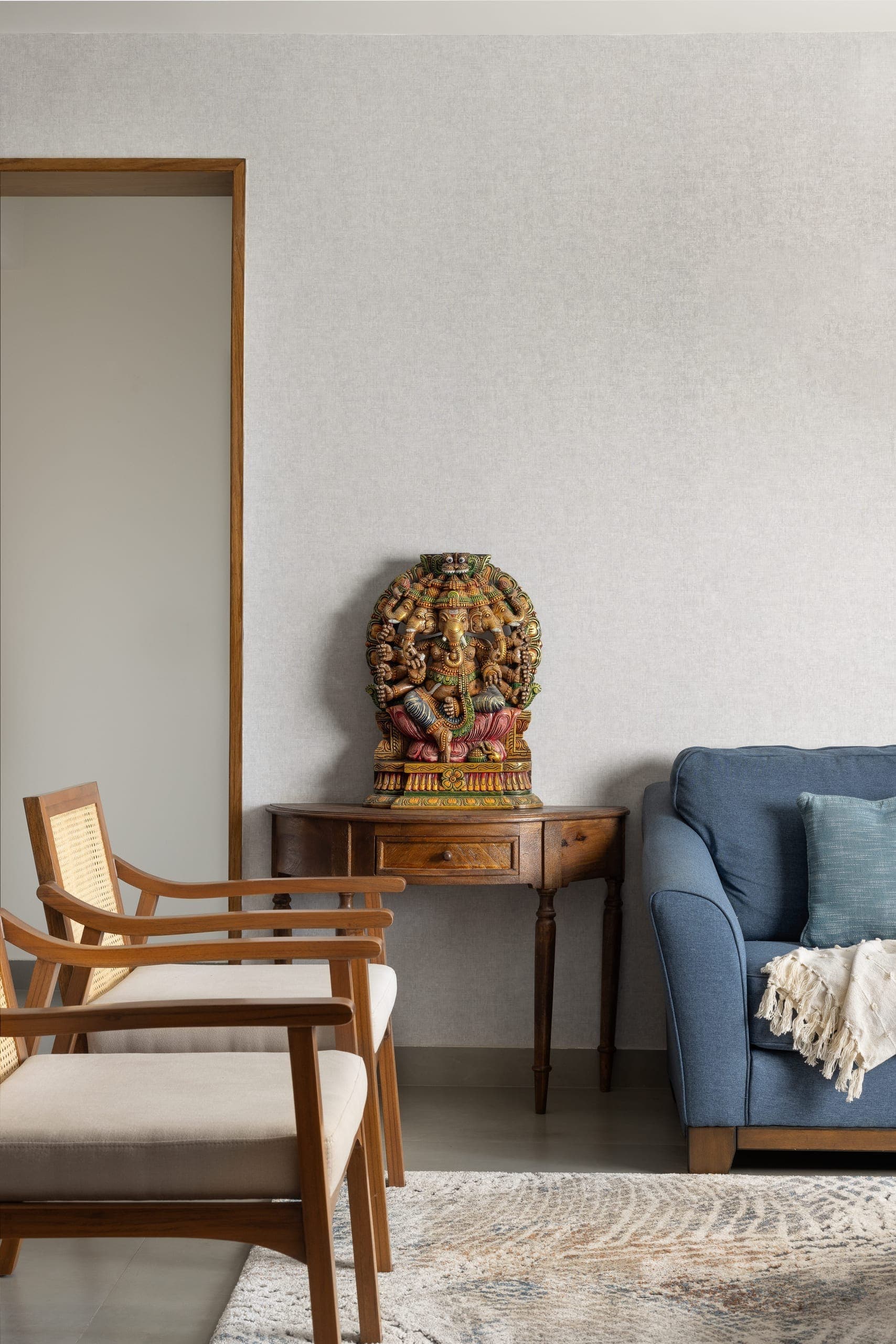 The living room is oriented around conversation and the view, with no television interrupting the space. Teak and cane furniture set a warm, tactile base, while lighting combines functional fixtures with pieces sourced locally. Subtle Indian influences come through in the decor, fabrics, and artwork, many commissioned directly from rural artisans, reflecting a conscious effort to support craft at its source.