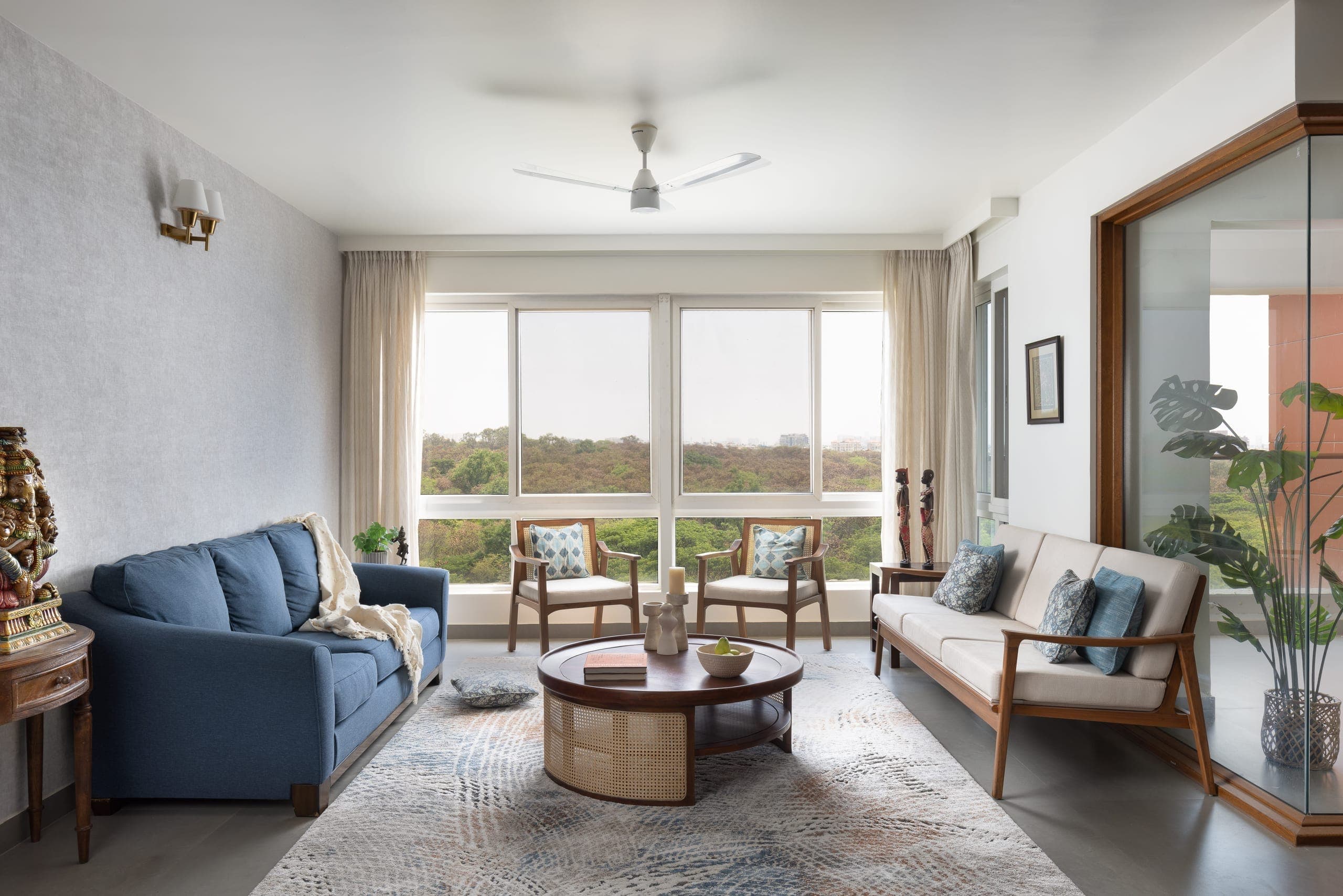 Instead of enclosing the small balcony to expand the living room, it was extended by combining it with the adjacent library and TV area. An L-shaped glass enclosure defines it from the living and dining spaces while keeping it visually connected.